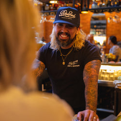 Bar staff member wearing BSMC Garage Cap - Navy/White