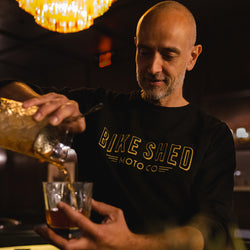 Bar staff member make a cocktail wearing our BSMC Deco Sweat - Black/Gold