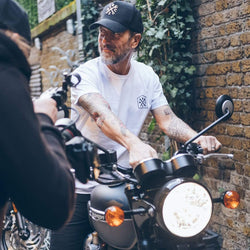 Dutch sitting on a Triumph Bonnie wearing our BSMC 1580 Roundel T Shirt - White