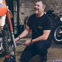 Dan working on his bike while wearing our BSMC ESTD. Pocket T Shirt - Black & Gold