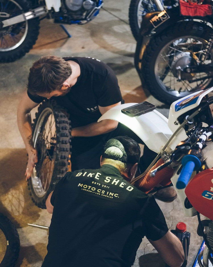 Gareth and Dan working on their bikes while wearing our BSMC ESTD. Pocket T Shirt - Black & Gold