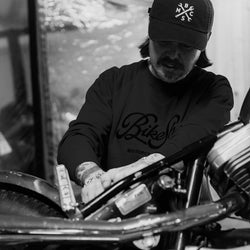 James wearing our BSMC Garage Sweat - Washed Black while working on his bike