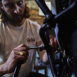 Gareth working on his bike while wearing our BSMC Handmade T Shirt - Cream