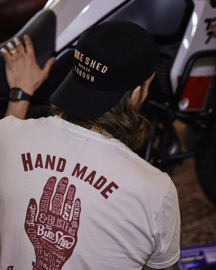 Gareth inspecting his bike while wearing our BSMC Handmade T Shirt - Cream
