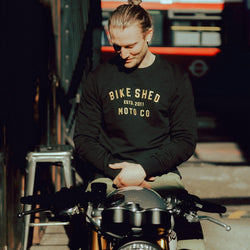 Steve sitting on his Triumph wearing our BSMC Moto Co. Sweat - Black/Gold