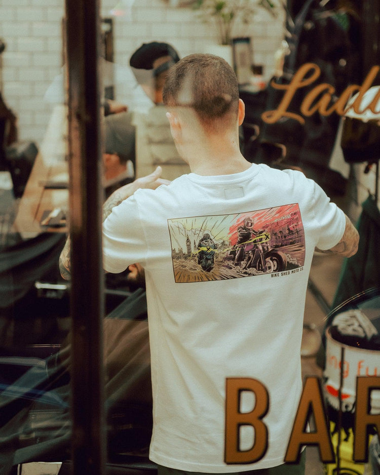Luca wearing our BSMC Mural T Shirt - White while cutting hair
