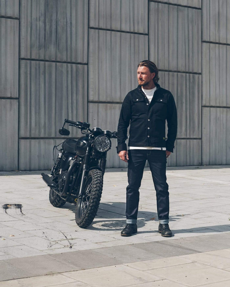 Donny, wearing our BSMC Resistant - BSR01 Jean - Raw Indigo standing next to his Triumph
