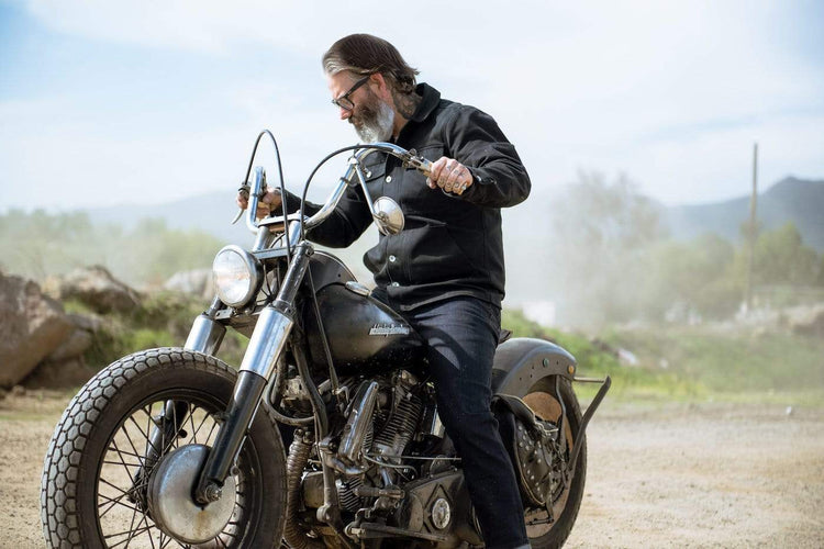Model wearing our BSMC Resistant - BSR01 Jean - Raw Indigo while sitting on his bike