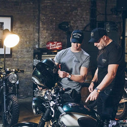 Dan wearing our BSMC Spanners Cap - Black & Gold while looking at Harry's bike