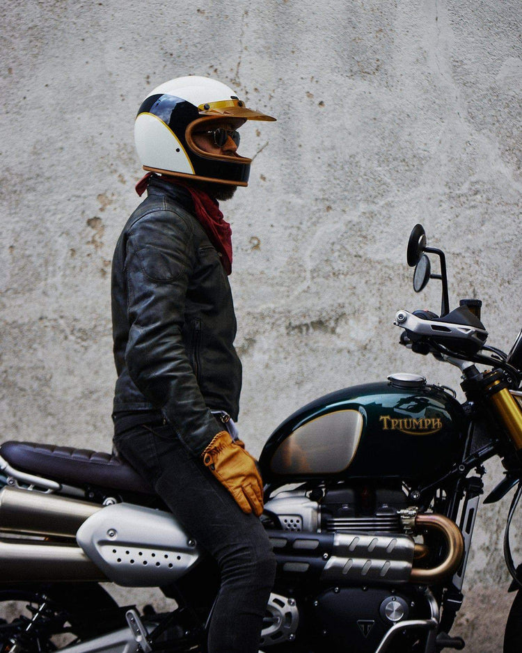 Model wearing our BSMC x Hedon Club Classic Helmet DOT sitting on his Triumph