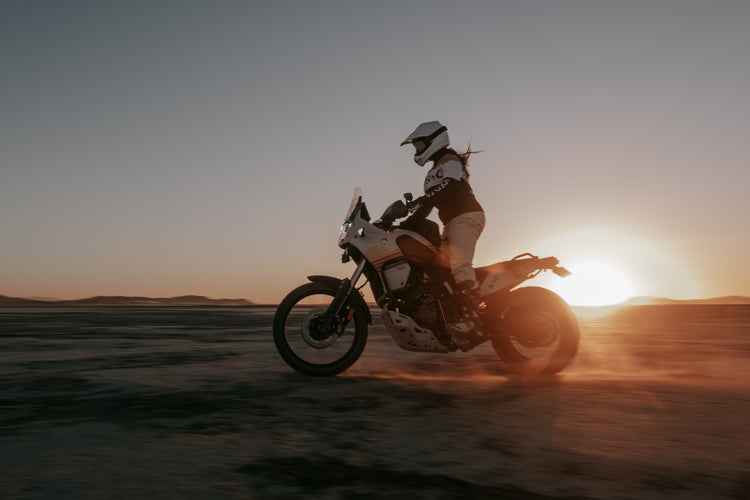 Caro riding her Tenere in the sunset wearing our BSMC Wing Race Jersey - Gold