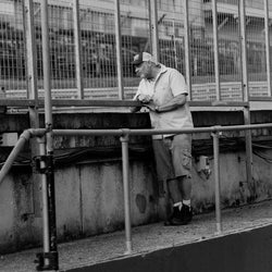 Dan watching bikes go by on a track day wearing our BSMC Garage Patch Shirt - Blue