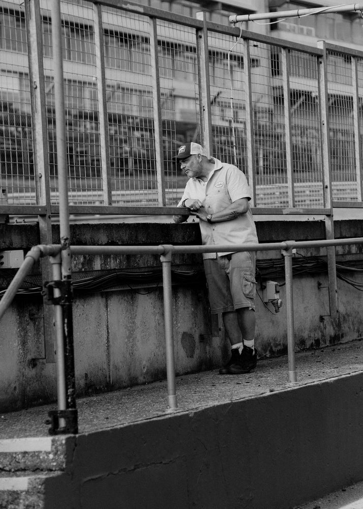 Dan watching bikes go by on a track day wearing our BSMC Garage Patch Shirt - Blue