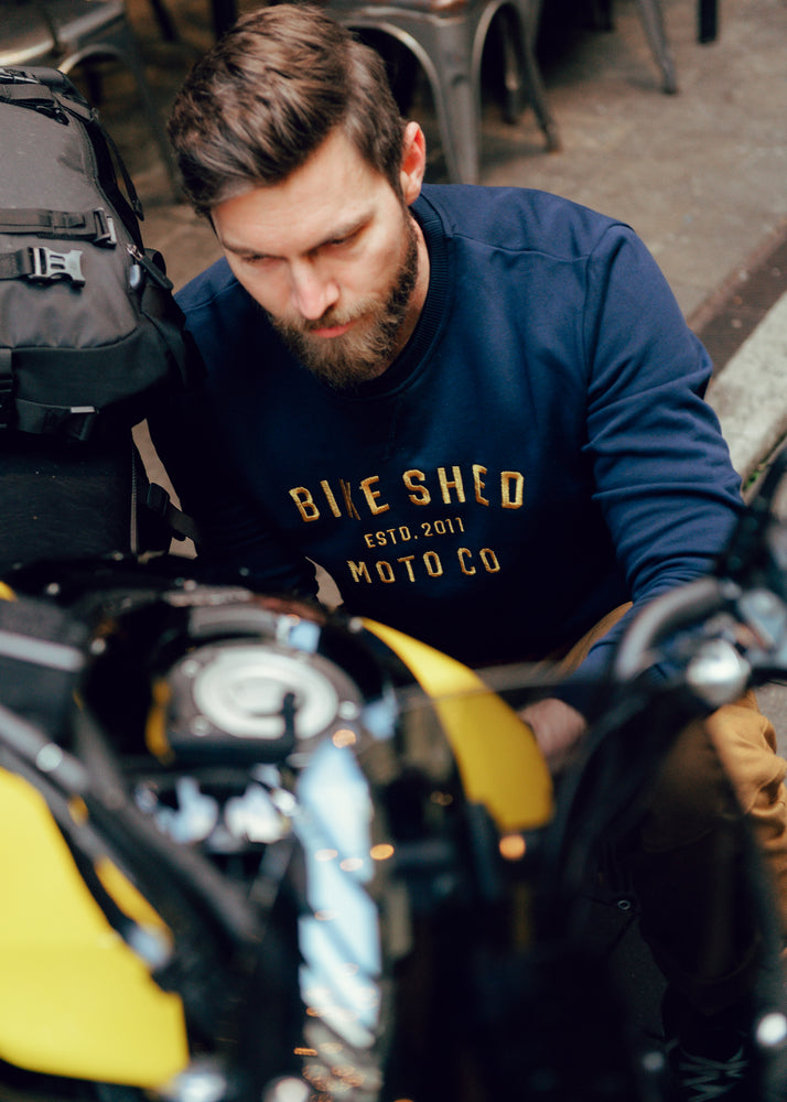 Alen inspecting his bike wearing our BSMC Moto Co. Sweat - Navy/Mustard