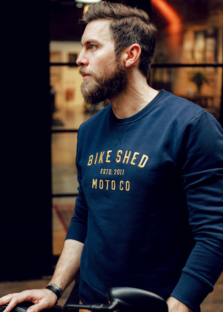 Alen posing, wearing our BSMC Moto Co. Sweat - Navy/Mustard